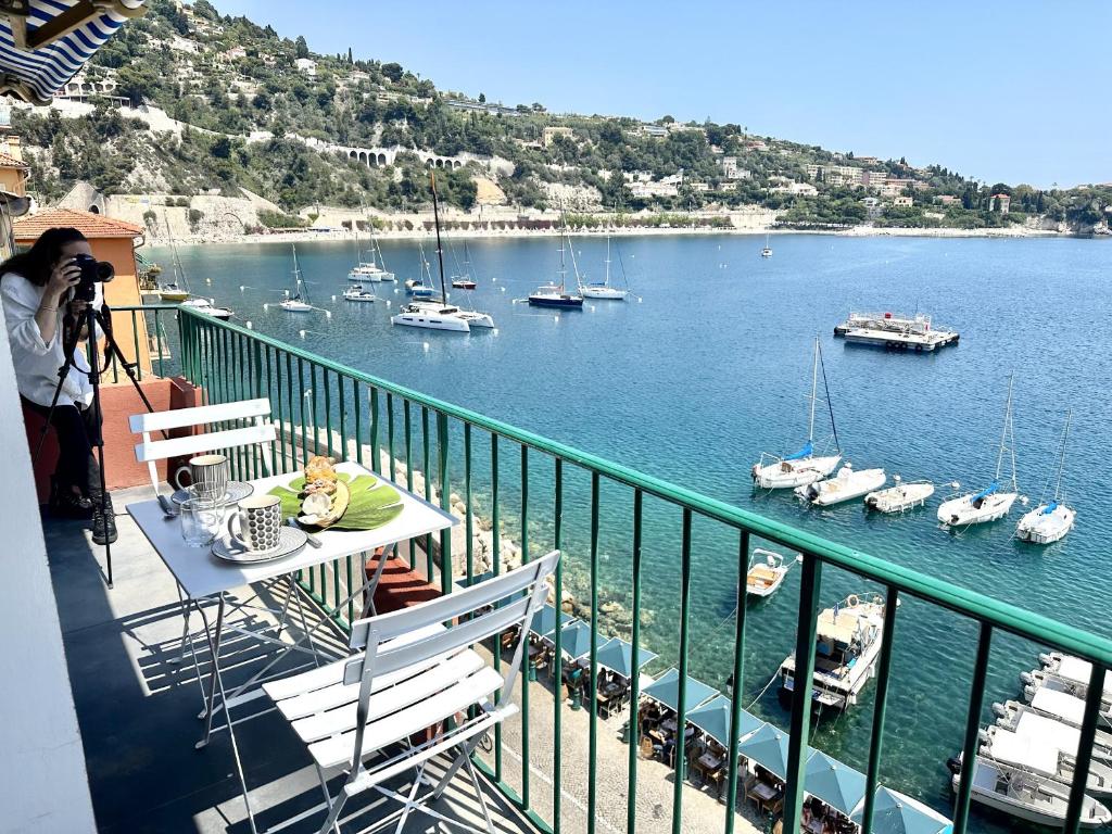 a person taking a picture of a harbor with boats at MAISON BLEUE AP4362 By Riviera Holiday Homes in Villefranche-sur-Mer