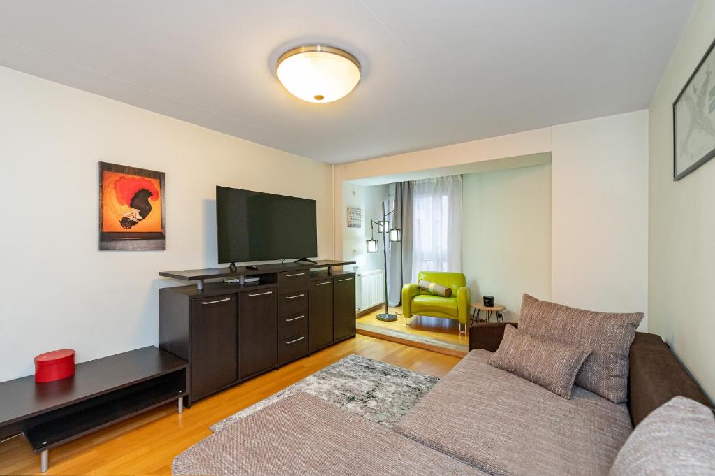 un soggiorno con divano e TV a schermo piatto di Charming city center apartment by Polo Apartments a Kaunas
