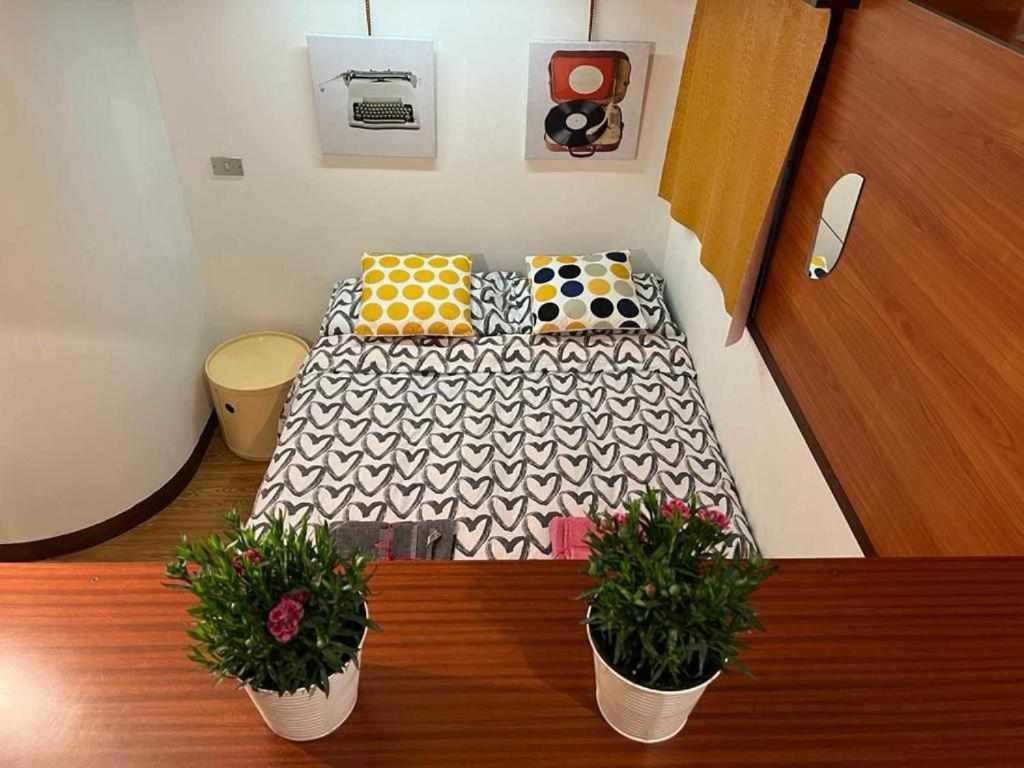 a small bed in a room with two potted plants at La Serra Olivetti in Ivrea