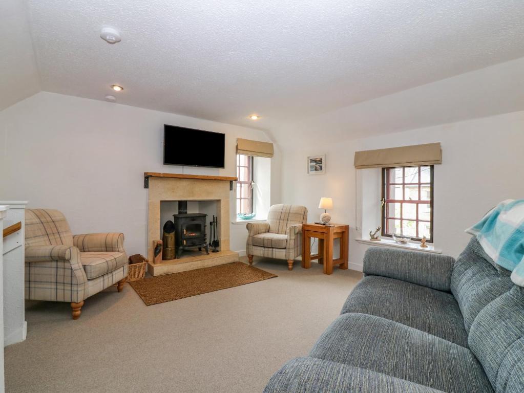 a living room with a couch and a fireplace at The Wee Hideaway in Cupar