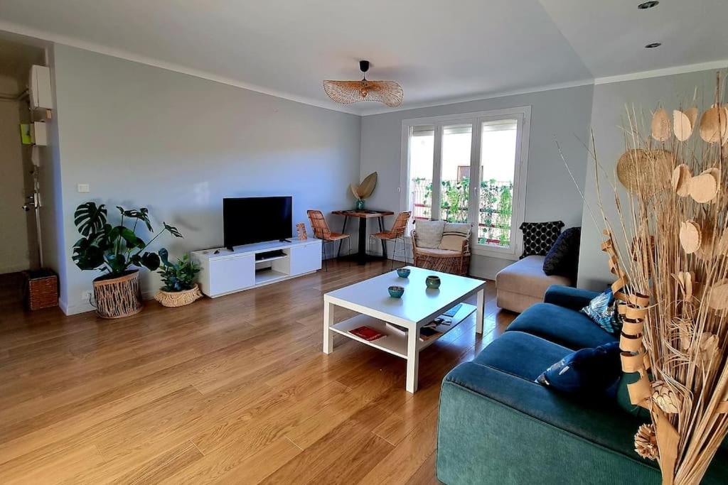 un salon avec un canapé bleu et une table dans l'établissement Appartement cosy proche du tram, à Montpellier