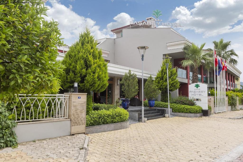 a white building with trees in front of it at Pasabey Hotel in Marmaris