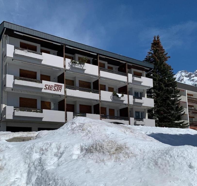 a building with a pile of snow in front of it at Siesta 3,5-Zimmer-Wohnung in Leukerbad