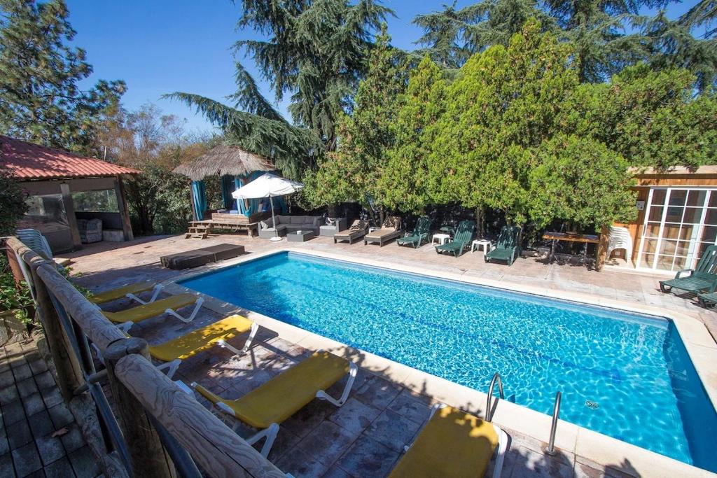 - une piscine entourée de chaises longues et de chaises dans l'établissement Catalunya Casas An oasis for up to 26 nature loving guests!, à Sils