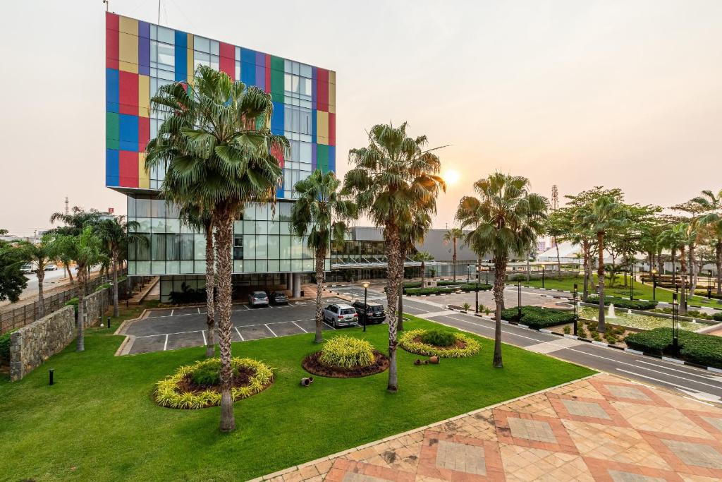un edificio de oficinas con palmeras delante en Hotel de Convenções de Talatona, HCTA en Luanda