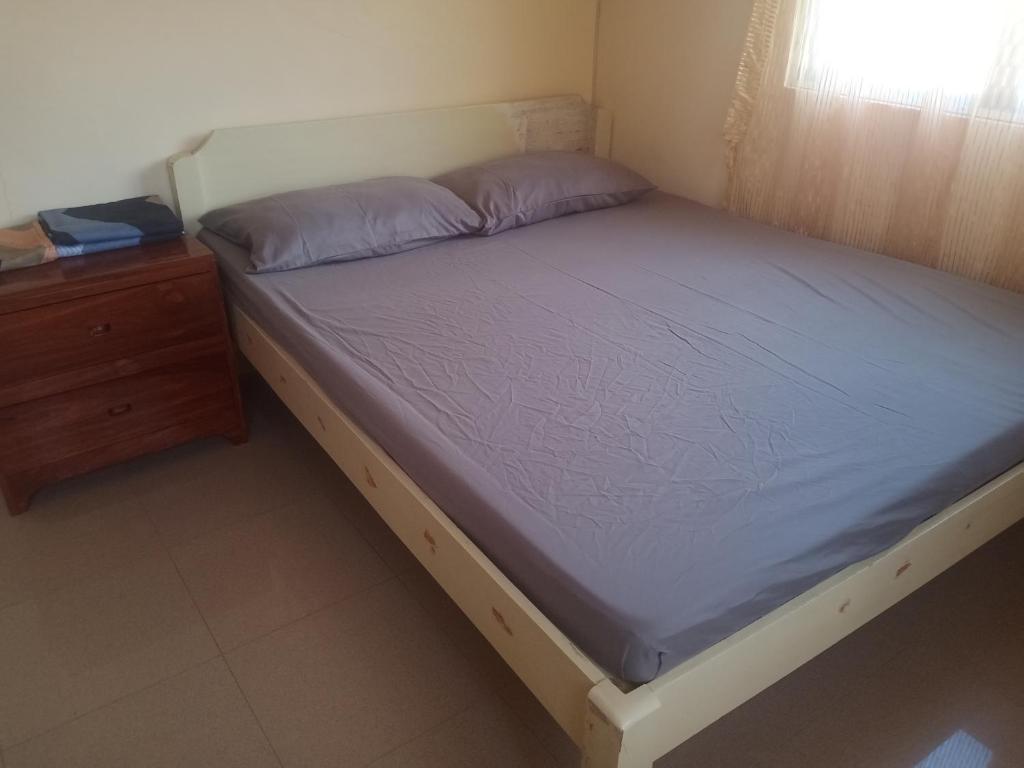 a bed in a room with a nightstand and a bed sidx sidx at Room in Lobo Triple N Homestay 3rd N 