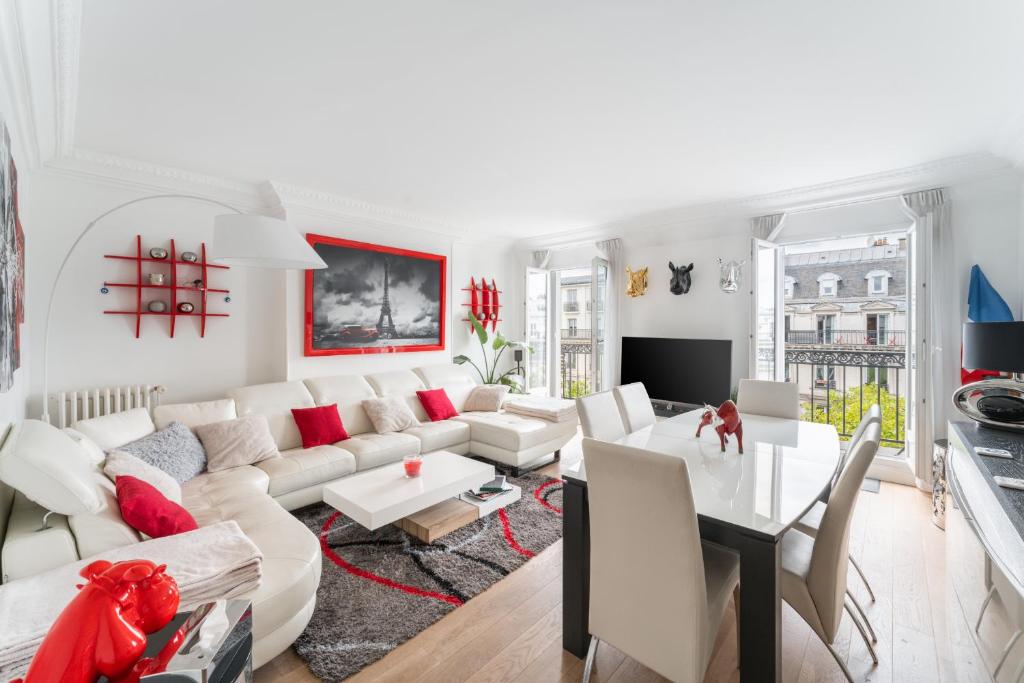 un salon avec un canapé blanc et une table dans l'établissement Appartement Haussmannien - dernier étage, à Paris