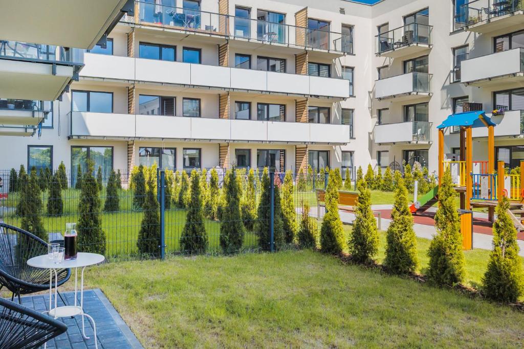 an apartment building with a garden in front of it at Gdynia Nasypowa Apartments with Parking by Renters in Gdynia