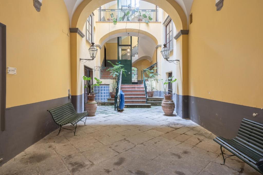 un couloir avec deux bancs et des escaliers dans un bâtiment dans l'établissement The Charming Suites, à Sorrente