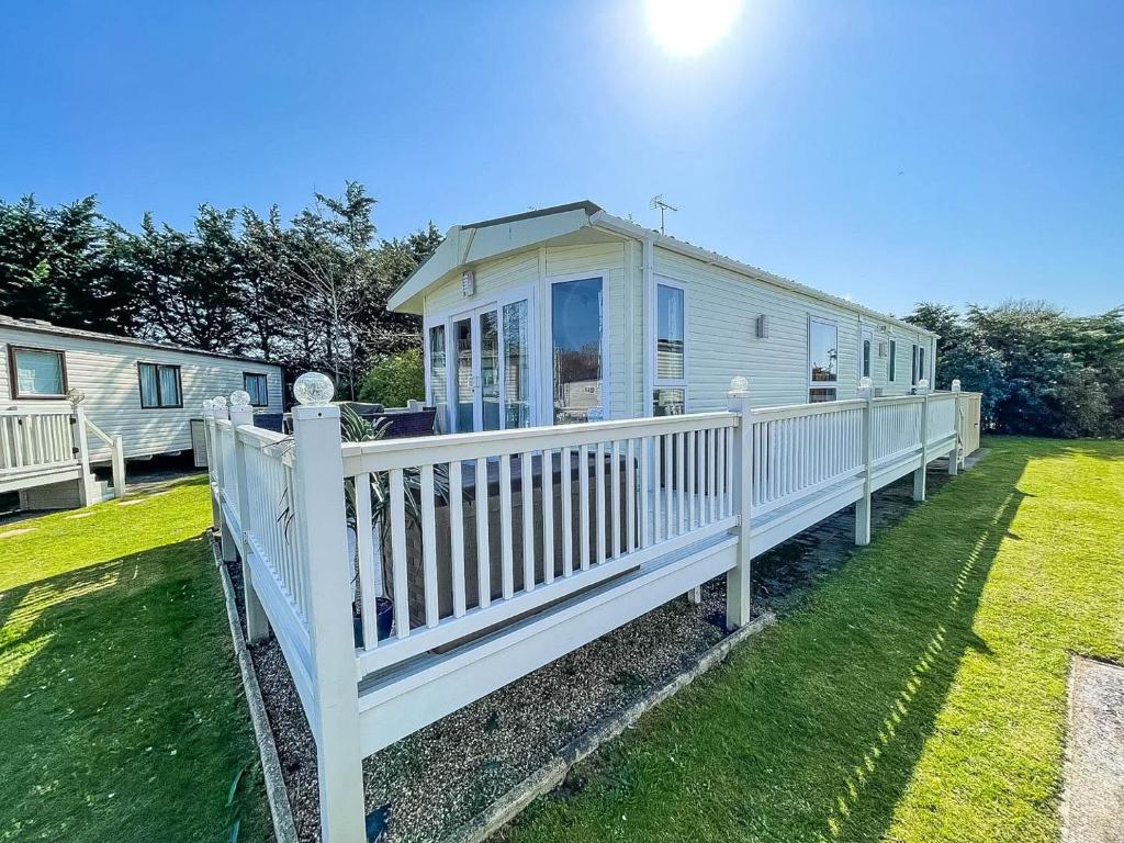 a white mobile home with a white fence at 6 Berth Caravan With Decking At Cherry Tree Park In Norfolk Ref 70014g in Great Yarmouth