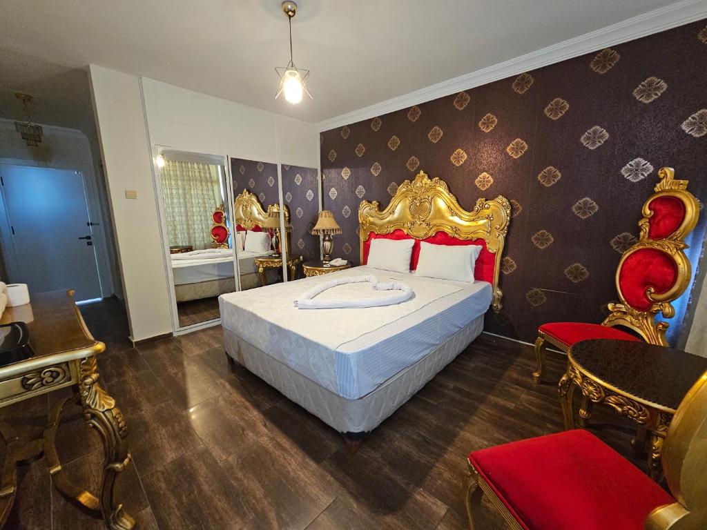 a bedroom with a large bed with a gold headboard at Altın Koza Hotel in Adana