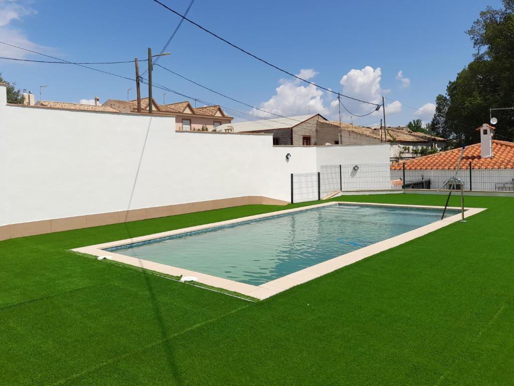una piscina en un patio con césped verde en Alojamientos Rurales Villora, en Murcia
