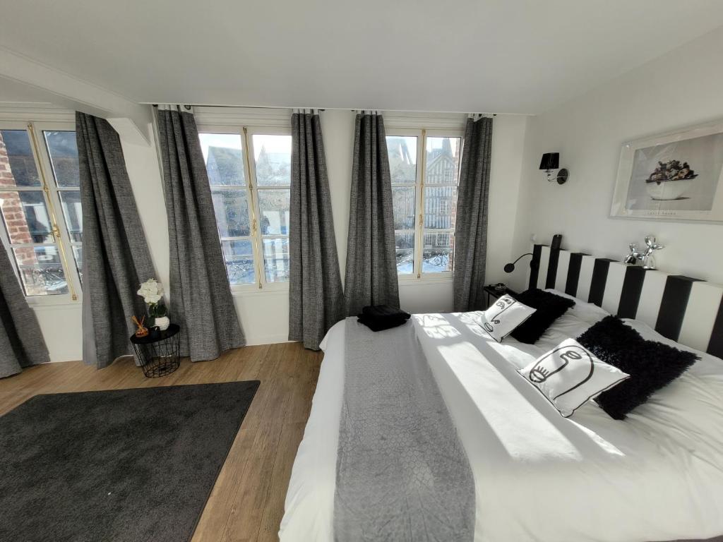 1 dormitorio con 1 cama blanca grande y ventanas en La maison père camembert, en Honfleur