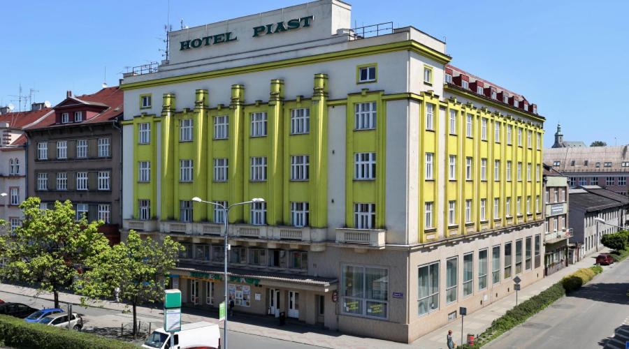 un edificio giallo sul lato di una strada di Hotel Piast a Český Těšín