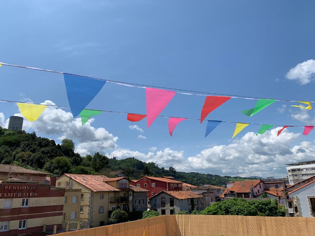 una bandera colorida colgando sobre una ciudad en casa loopez Hostel en Laredo