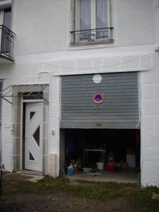 eine Garage mit Garagentor und einem Gebäude in der Unterkunft Penotte in Saint-Chély-dʼApcher