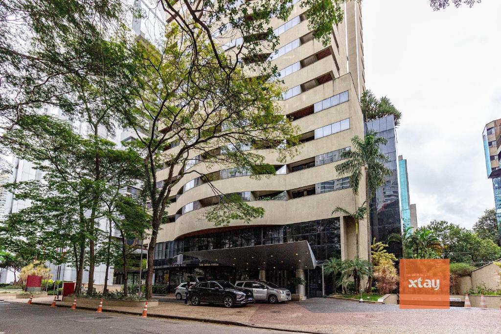 um edifício com dois carros estacionados em frente em Xtay São Paulo Berrini em São Paulo