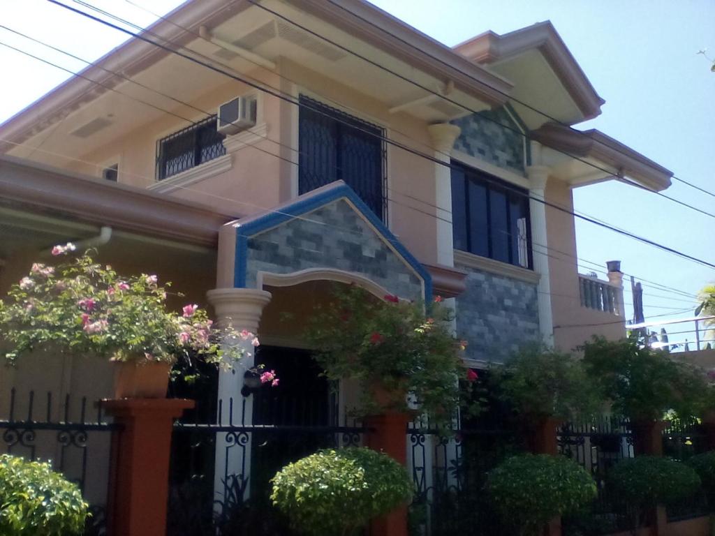 une maison avec une clôture et des fleurs dans l'établissement Gallery, air-conditioned room with double bed Bathroom Toilet Pools Beaches around the corner, à Gabi