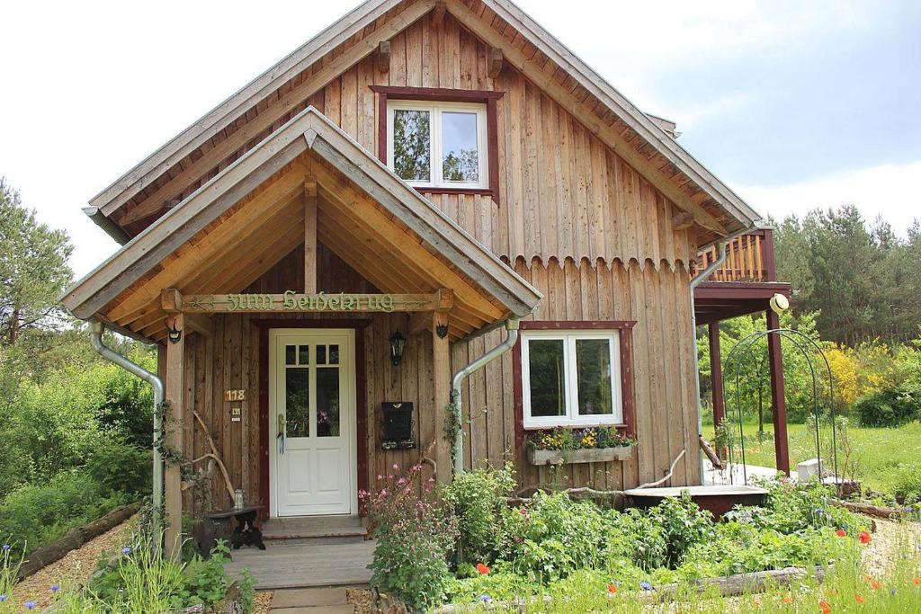 Cette petite maison en bois est dotée d'une porte blanche. dans l'établissement Ferienhaus "Am Wegesrand", 