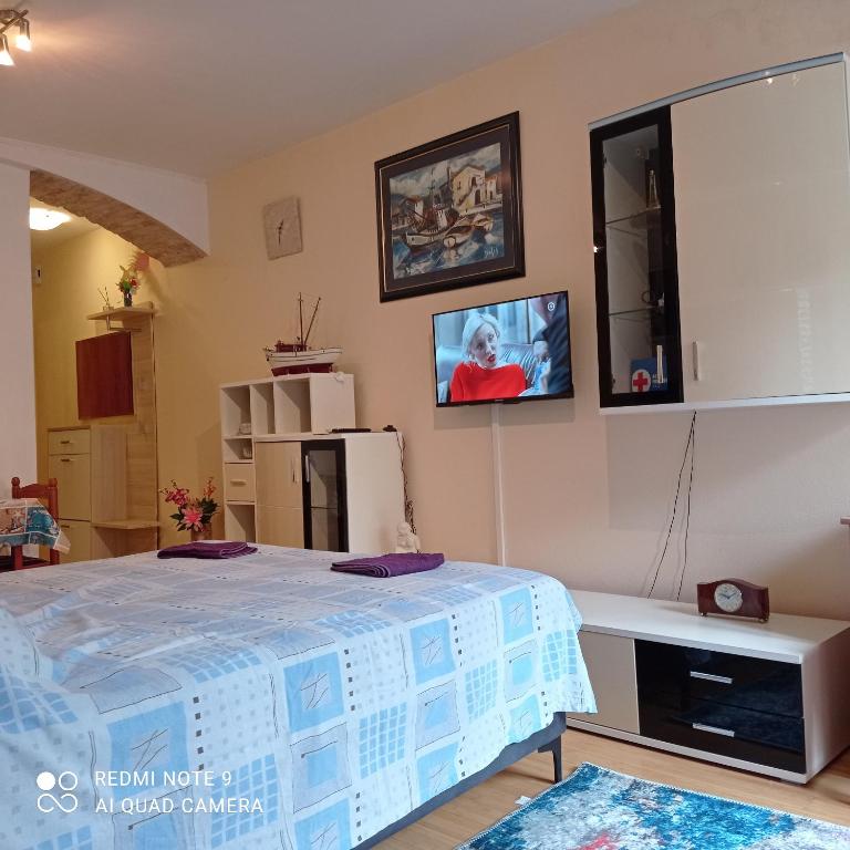 a bedroom with a bed and a tv on the wall at Studio Cres in Cres