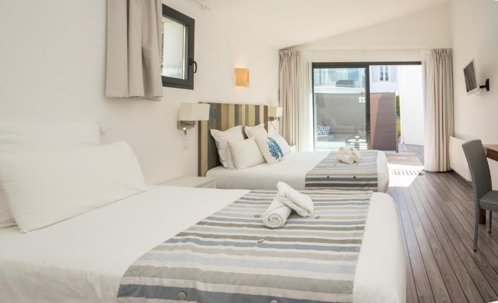 um quarto de hotel com duas camas com toalhas em Hôtel Le Square em Saint-Pierre-dʼOléron