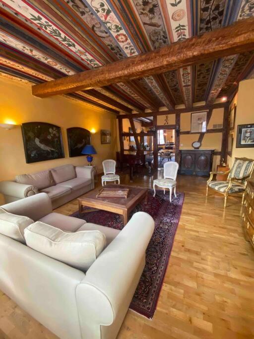 un salon avec un canapé blanc et une table dans l'établissement Le Majestueux dans le centre historique, à Riquewihr