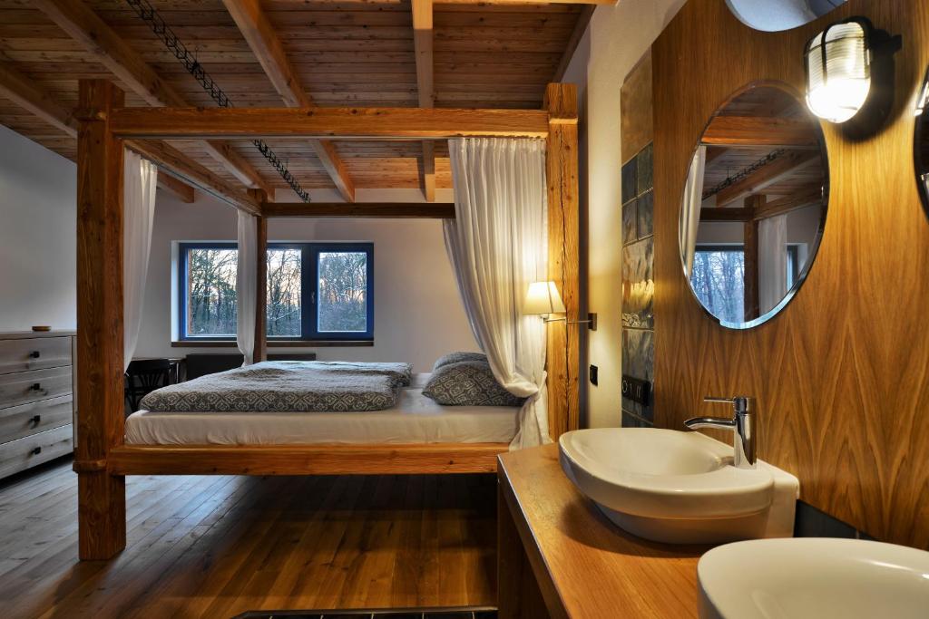 een slaapkamer met een bed, een wastafel en een spiegel bij Farma Noe in Březina