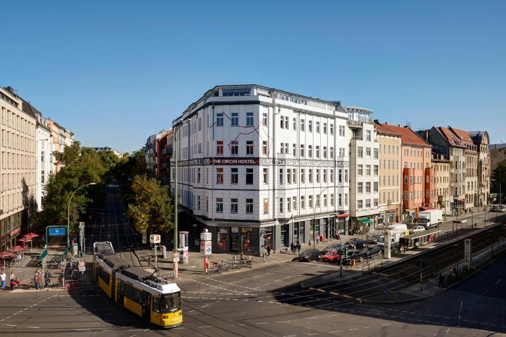 ein gelber Bus auf einer Stadtstraße mit einem Gebäude in der Unterkunft The Circus Hostel in Berlin