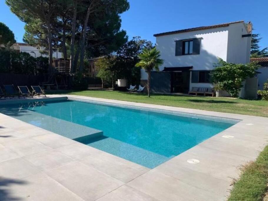 una piscina di fronte a una casa di Casa exclusiva, jardín y piscina privada a Calella de Palafrugell