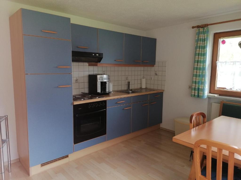 eine Küche mit blauen Schränken und einem Herd mit Backofen in der Unterkunft Ferienwohnung Pohl in Bach