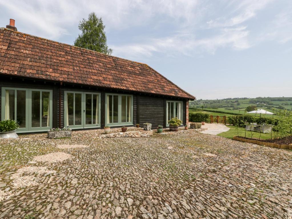 a house with a brick driveway in front of it at The Shippon in Honiton