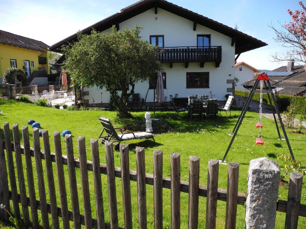 a fence in front of a house with a swing at Ferienwohnungen Hauner in Viechtach