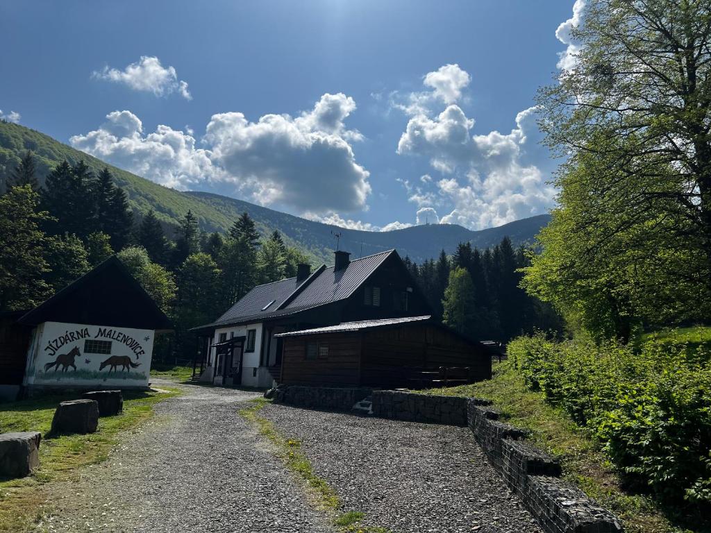 un bâtiment avec un panneau placé à côté d'une route dans l'établissement Jízdárna Malenovice, à Malenovice