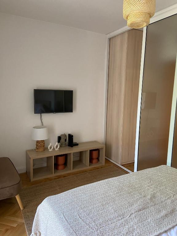 sypialnia z łóżkiem i telewizorem na ścianie w obiekcie Apartman Val w mieście Zadar