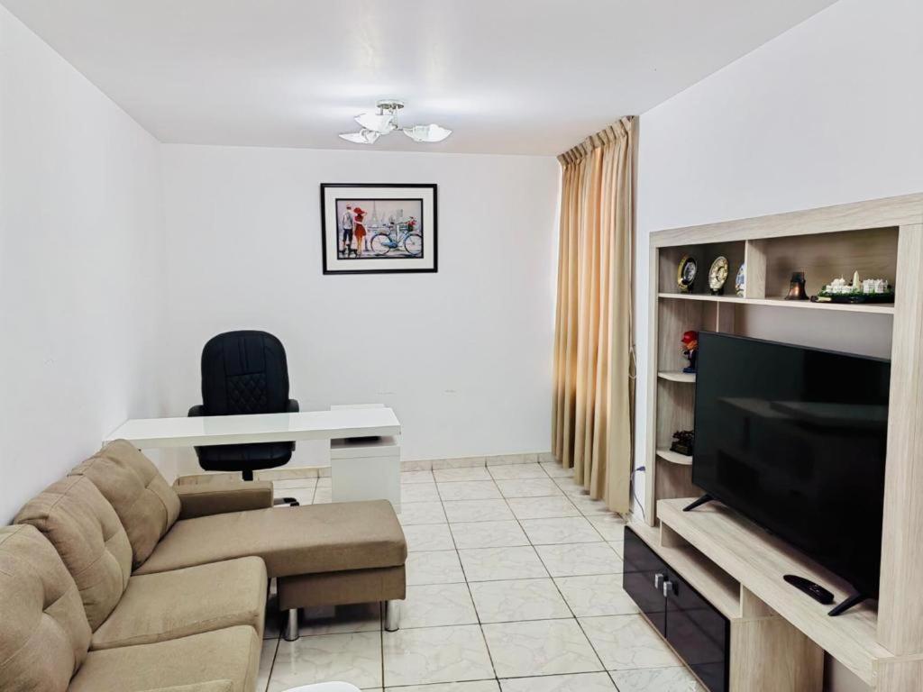 a living room with a couch and a television at Apartamento en el Centro de Trujillo - Primer Piso in Trujillo