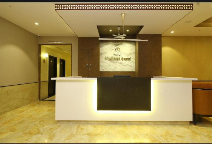 a lobby with a white and black counter top at Hotel Sindhura Grand in Hyderabad