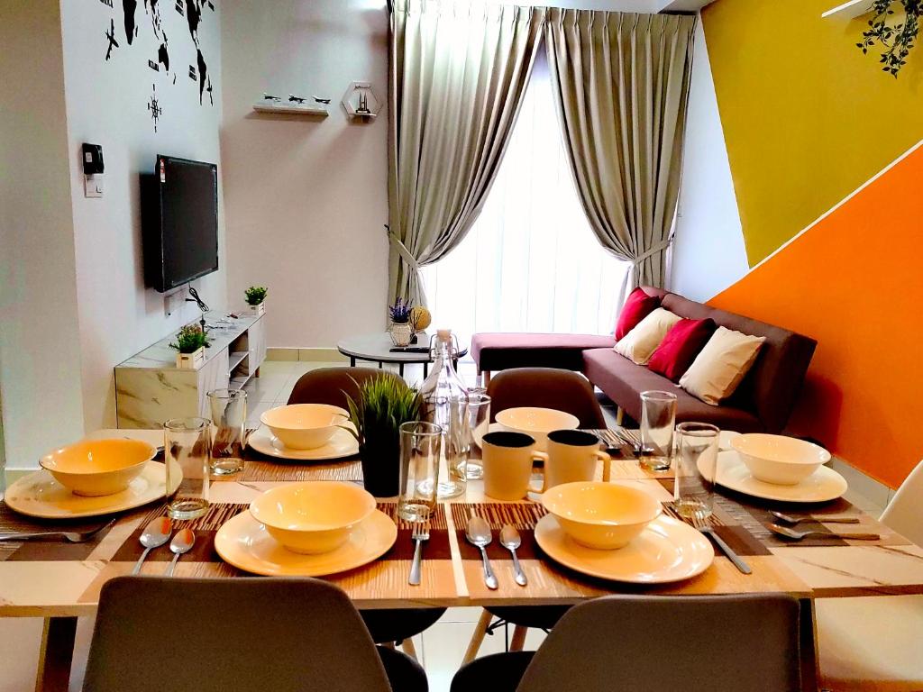 Alanis Residence 7 Pax @ Sepang KLIA Kota Warisan في سيبانغ: طاولة عليها صحون وصحون في غرفة المعيشة