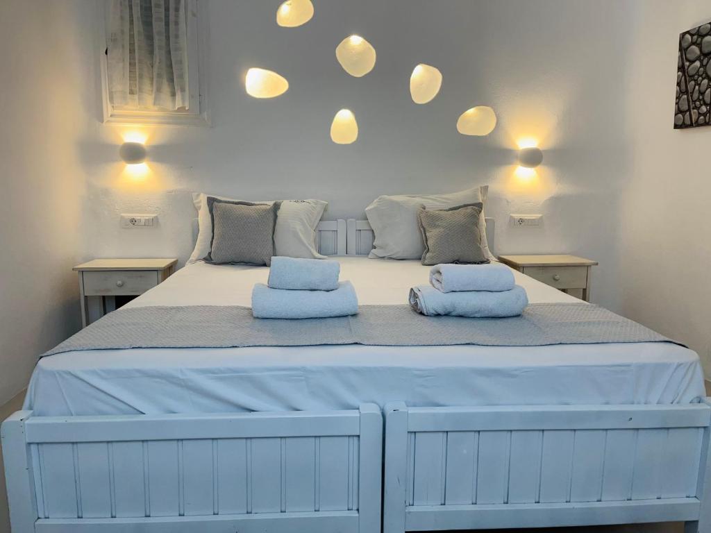 a large white bed with two pillows on it at Navy Blue Suites in Ornos