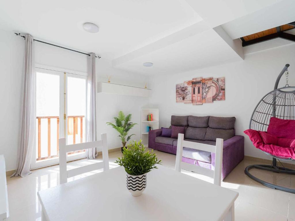Mahostly Sun and Spa في بويرتو ديل روزاريو: غرفة معيشة مع أريكة أرجوانية وطاولة