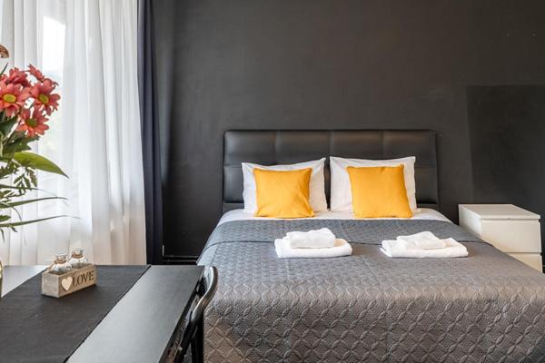 a bedroom with a bed with orange pillows and a table at Albert gare du Midi 31 in Brussels