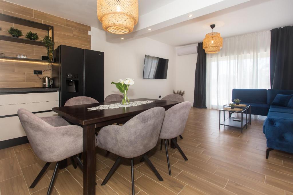 sala de estar con mesa de comedor y sillas en Angolo Apartments, en Kaštela