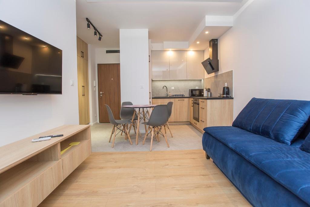 比亚韦斯托克Urban Jungle apartament Alice的带蓝色沙发的客厅和厨房