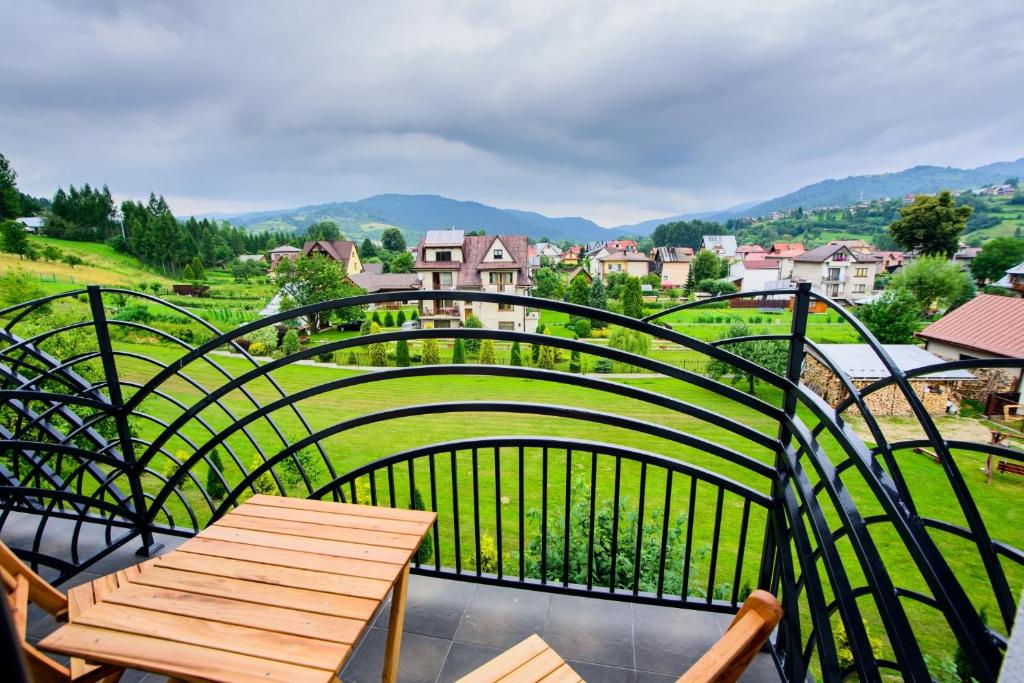 uma varanda com uma mesa de madeira e uma cerca em Otulina Park em Krościenko