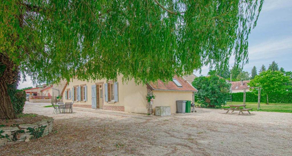 ein Gebäude mit einem Picknicktisch und einem Baum in der Unterkunft La brosse fleury in Montfey