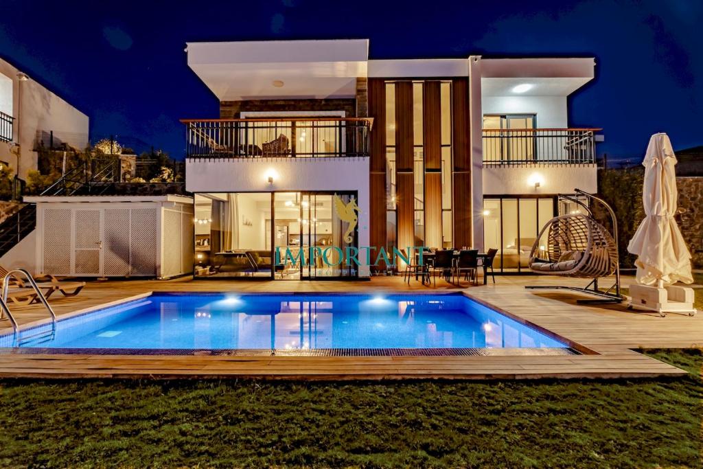 uma villa com piscina em frente a uma casa em Farilya Villas by Important Group Travel em Bodrum City