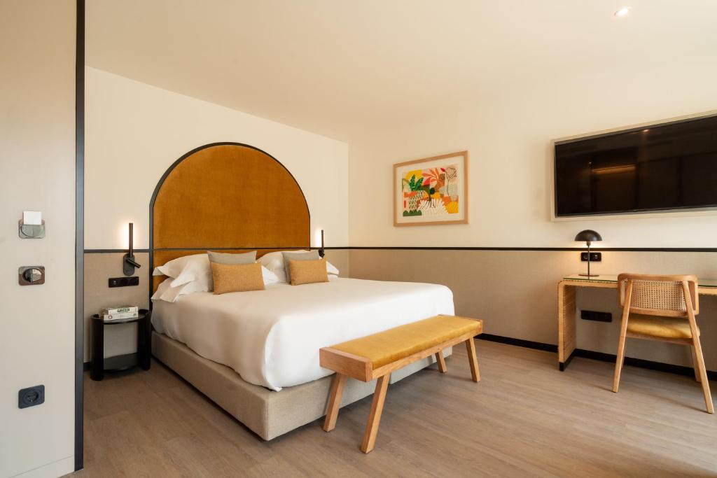 a bedroom with a bed and a table and a desk at The Editory Garden Porto Hotel in Porto