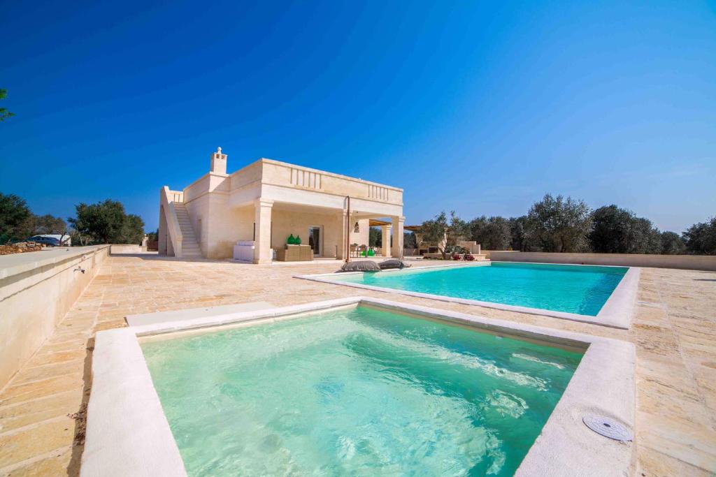 une piscine devant une maison dans l'établissement Antica Pietra - Villa con piscina in Puglia, à Ostuni