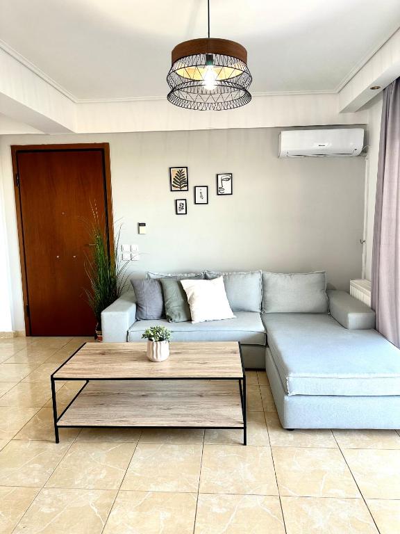 Kallikratis Apartment Near Athens Airport في سباتا: غرفة معيشة مع أريكة وطاولة قهوة