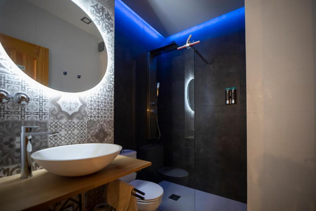 a bathroom with a sink and a shower with a mirror at Carthago Suites (Centro - Casco histórico) in Cartagena