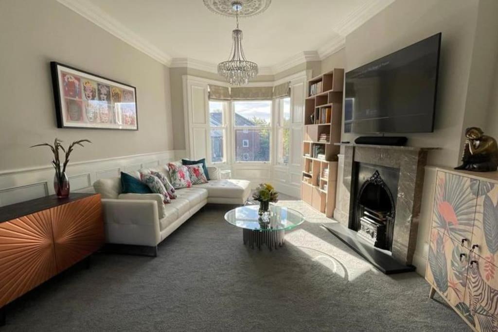 - un salon avec un canapé et une cheminée dans l'établissement Stunning 2 bed apartment in Jesmond, à High Heaton
